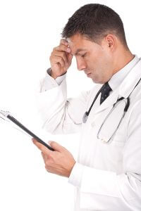 arts met stethoscoop kijkt op tablet