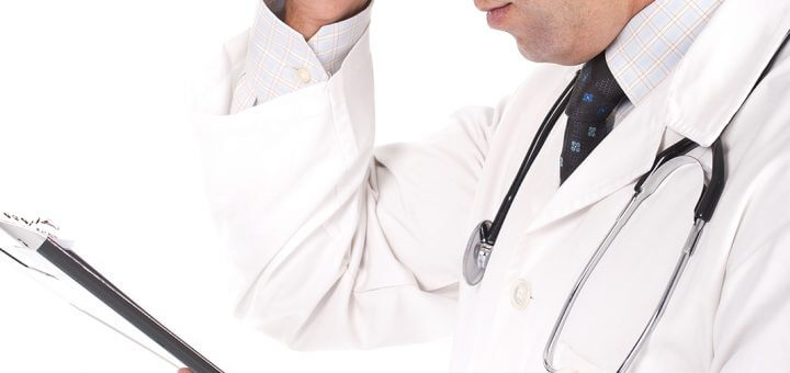 arts met stethoscoop kijkt op tablet