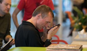Man houdt telefoon dichtbij de ogen. Toegankelijkheid, accessibility VIP
