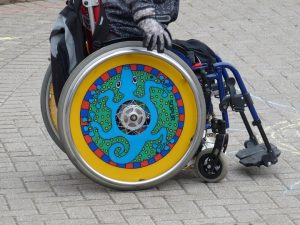 beperking handicap. Iemand in handrolstoel met afbeelding in het wiel
