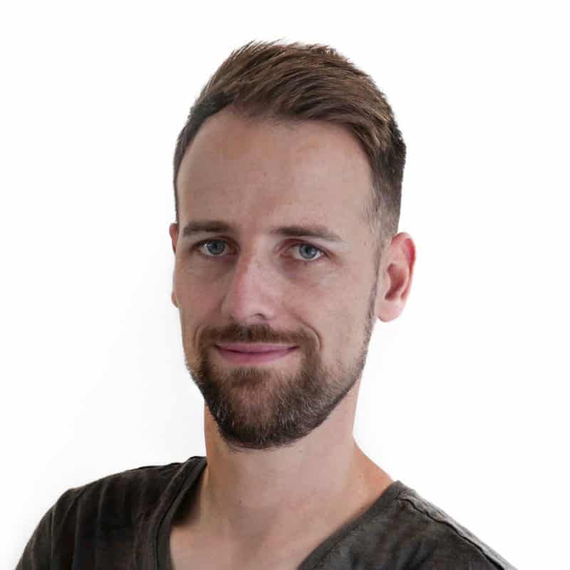 Een man met kort bruin haar en een baard, die een donker t-shirt draagt, poseert tegen een effen witte achtergrond en belichaamt de essentie van Nederlandse digitale soevereiniteit.