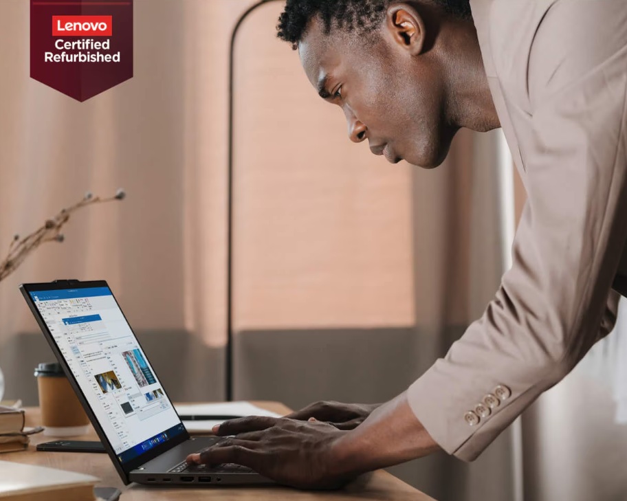Een persoon in een beige jas werkt aan een Lenovo laptop aan een bureau. Een "Lenovo Certified Refurbished" badge verschijnt in de linkerbovenhoek.