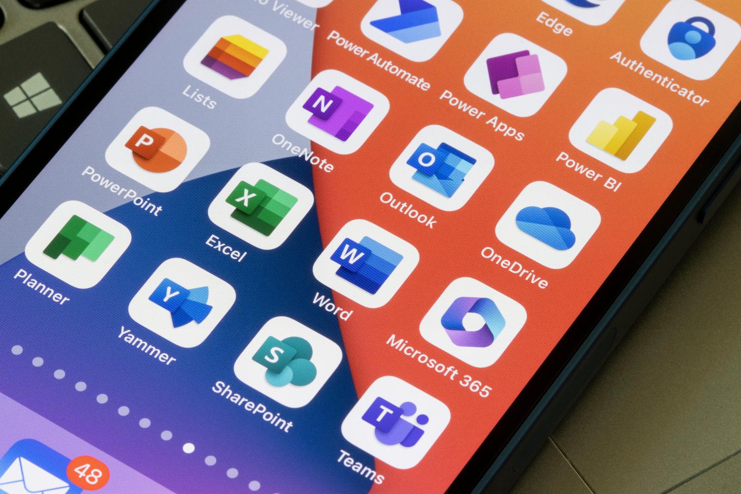 Op het scherm van een smartphone worden verschillende pictogrammen van Microsoft Office-apps weergegeven, waaronder Microsoft Outlook, Excel, Word, PowerPoint, Teams, OneDrive en meer.