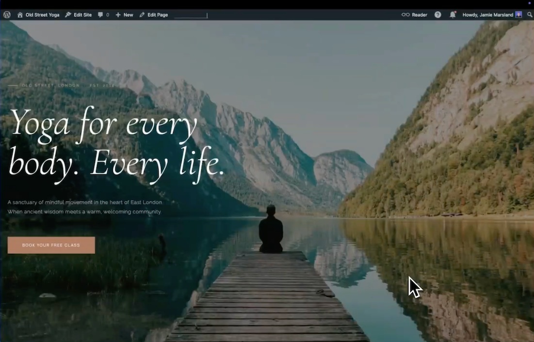 Een persoon zit aan het einde van een houten steiger op een meer omringd door bergen; tekst overlay luidt "Yoga voor elk lichaam. Elk leven.".