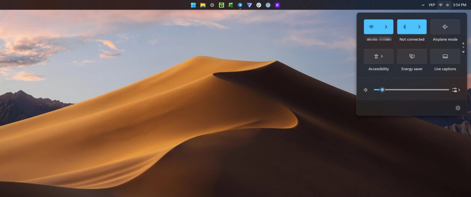 Een computerbureaublad met een achtergrond van woestijnduinen en een open instellingenmenu aan de rechterkant, met Wi-Fi niet verbonden en opties voor volume, batterij en toegankelijkheid.