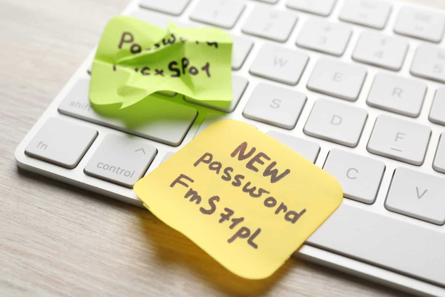 Twee plakbriefjes op een wit toetsenbord; op het ene staat "NIEUW wachtwoord FmS71pL," op het andere verkreukelde briefje staat gedeeltelijk "Wachtwoord.